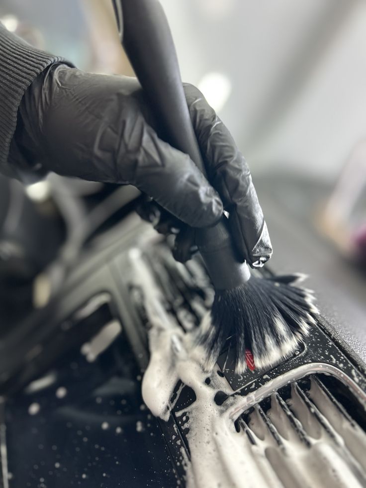 Técnico de HC Detailing limpiando interior de vehículo con herramientas profesionales